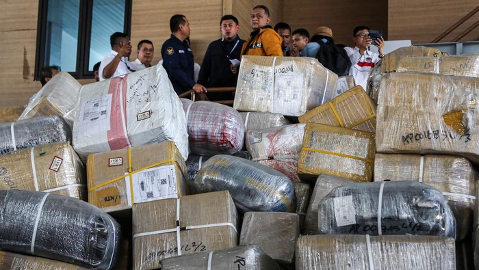 Kepala Badan Perlindungan Pekerja Migran Indonesia (BP2MI) Benny Rhamdani (tengah, atas) mengecek tumpukan kardus paket barang kiriman Pekerja Migran Indonesia (PMI) di PT MAJ Logistik Indonesia, Semarang, Jawa Tengah, Rabu (5/6/2024). Lebih dari 20 ribu kardus barang kiriman PMI masih tertahan selama lima hingga enam bulan di sejumlah gudang milik perusahaan jasa titipan barang di Kota Semarang dan akan segera ditindaklanjuti untuk mempermudah barang keluar ke tempat tujuan masing-masing serta paket kiriman itu dinyatakan bukan termasuk barang komersial. ANTARA FOTO/Makna Zaezar/nym.