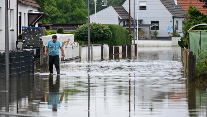 Penampakan Rumah-rumah di Jerman Kebanjiran Usai Diguyur Hujan Lebat A man walks through a flooded area in Reichertshofen, near Ingolstadt, Germany, June 3, 2024. REUTERS/Angelika Warmuth