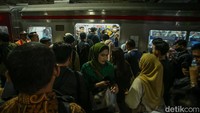 Baik pekerja muda maupun tua berhimpitan untuk masuk ke kereta.
