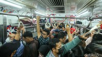 Meski penat usai melaksanakan pekerjaannya di kantor, para pekerja masih harus berjibaku untuk segera masuk ke kereta tujuan.