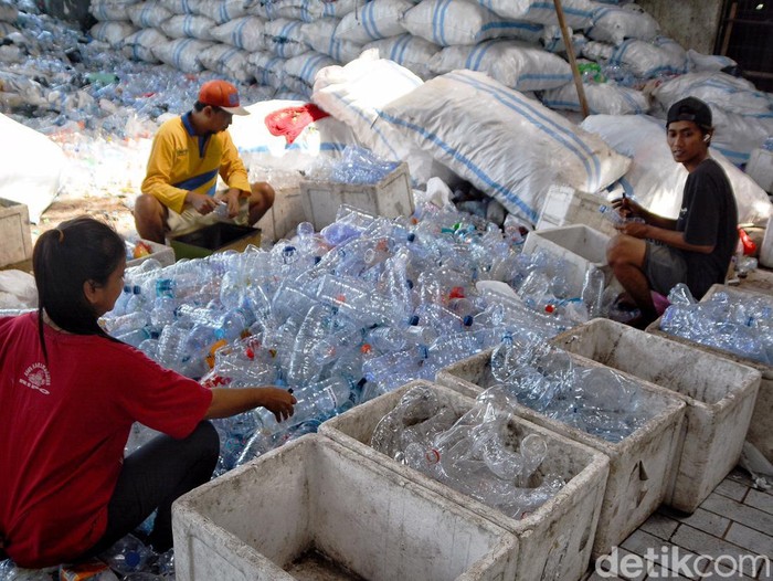 Tiga pekerja saat memilah botol plastik di rumah kompos Rungkut