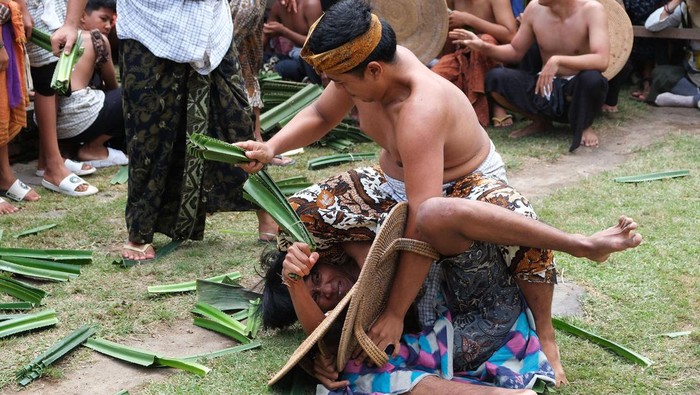 Dua warga saling menyerang dengan daun pandan berduri saat Tradisi Perang Pandan di Desa Tenganan Pegringsingan, Karangasem, Bali, Rabu (5/6/2024). Tradisi tahunan yang dilakukan warga setempat sebagai bentuk penghormatan kepada Dewa Indra atau Dewa Perang tersebut disaksikan oleh ribuan penonton dari kalangan pelajar, konten kreator, dan wisatawan mancanegara. ANTARA FOTO/Nyoman Hendra Wibowo/foc.