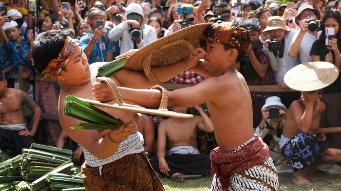 Tradisi Perang Pandan di Desa Tenganan Bali Dua warga saling menyerang dengan daun pandan berduri saat Tradisi Perang Pandan di Desa Tenganan Pegringsingan, Karangasem, Bali, Rabu (5/6/2024). Tradisi tahunan yang dilakukan warga setempat sebagai bentuk penghormatan kepada Dewa Indra atau Dewa Perang tersebut disaksikan oleh ribuan penonton dari kalangan pelajar, konten kreator, dan wisatawan mancanegara. ANTARA FOTO/Nyoman Hendra Wibowo/foc.