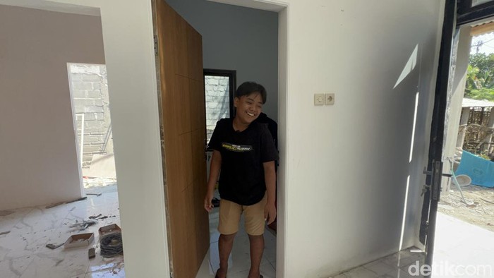 Adit tampak bahagia rumahnya direnovasi.