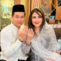 Digelar secara sederhana, keduanya tampil kompak mengenakan busana bernuansa putih untuk akad nikah. Barbie Kumalasari tampak mengenakan kebaya abu-abu muda dipadukan dengan selendang penutup kepala berwarna putih dan kain bawahab coklat. Sementara suaminya tampil simpel mengenakan baju koko warna putih lengkap dengan kopiah hitam yang senada dengan celana panjang yang dikenakannya. Foto: Instagram/@barbiekumalasari