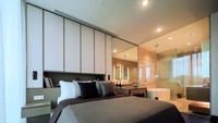 Kamar Tidur Utama didesain untuk menenangkan, menggunakan material berwarna hangat yang mewah.  