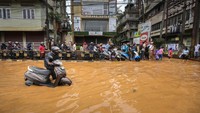Pengendara nekat menerobos banjir yang merendam jalan raya.