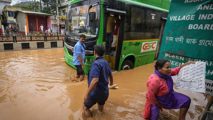A family on a scooter wades through a flooded street after heavy monsoon rains in Guwahati, India, Wednesday, June 5, 2024. (AP Photo/Anupam Nath)