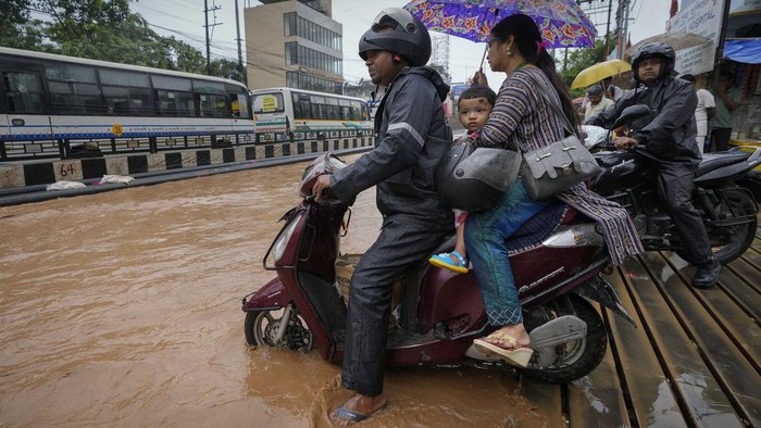 Jalanan di Guwahati India Terendam Banjir Akibat Hujan Lebat A family on a scooter wades through a flooded street after heavy monsoon rains in Guwahati, India, Wednesday, June 5, 2024. (AP Photo/Anupam Nath)
