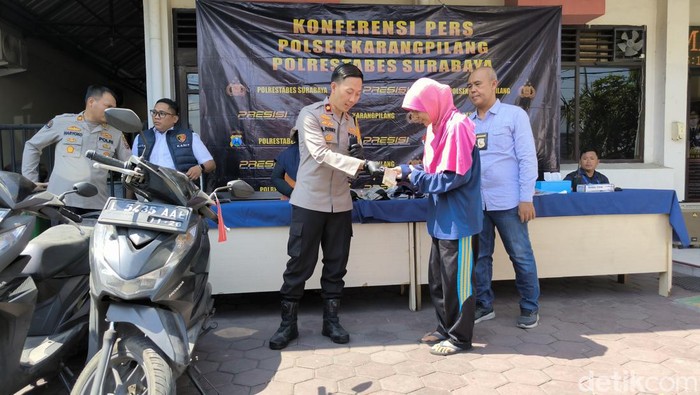 Kapolsek Karang Pilang saat mengembalikan kunci motor milik Sari.
