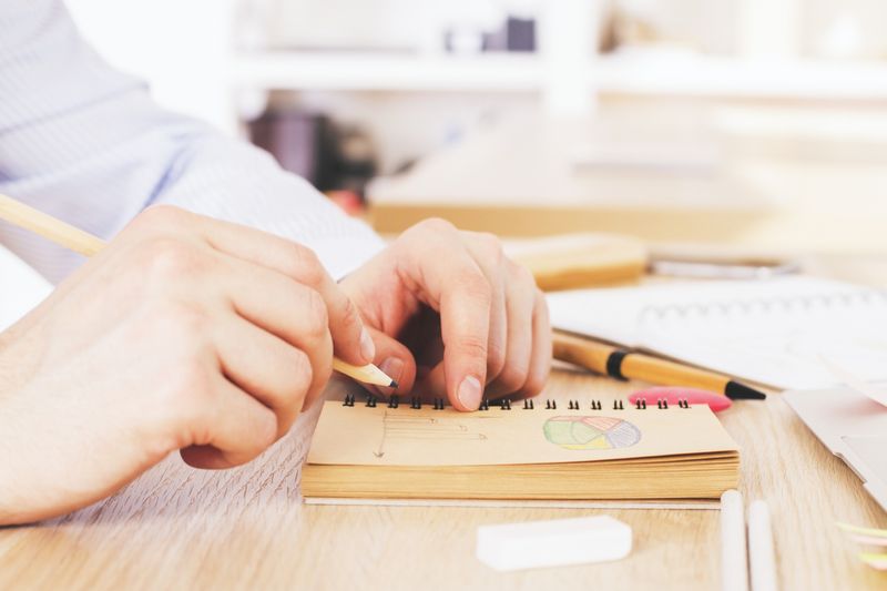 Kegiatan Visual Journaling Watercolor paint canva and brushes used to create new paintings. Hand holding a brush. Starting a bullet journal in a dot notebook. New beginnings. Art and creativity concept.