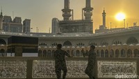Dua orang petugas keamanan berjaga di Masjidil Haram saat mahatari hampir terbenam di Makkah, Arab Saudi.