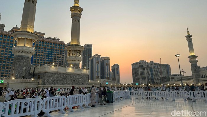 Dua orang petugas keamanan berjaga di Masjidil Haram saat mahatari hampir terbenam di Makkah, Arab Saudi.