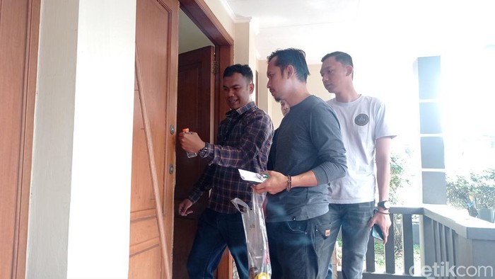 Polisi sedang memeriksa pintu rumah korban pencurian di Tasikmalaya.