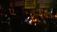 Sejumlah warga menyantap makanan di sebuah warung dengan penerangan lilin saat terjadinya pemadaman listrik bergilir di Medan, Sumatera Utara, Rabu (5/6/2024). Pemadaman listrik tersebut terjadi sejak Selasa (4/6) karena adanya gangguan pada Transmisi Saluran Udara Tegangan Ekstra Tinggi (SUTET) 275 kV Linggau-Lahat, Sumatera Selatan. ANTARA FOTO/Fransisco Carolio. 