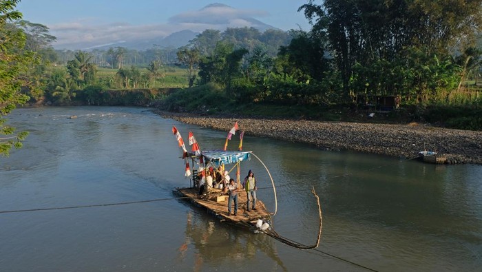 Warga menumpang getek atau rakit bambu saat menyeberangi Sungai Progo di Ngembik, Magelang, Jawa Tengah, Kamis (6/6/2024). Rakit bambu tersebut merupakan akses ekonomi dan pendidikan darurat bagi warga setempat karena jembatan gantung penghubung wilayah wilayah tersebut dengan Kota Magelang dalam proses pembuatan. ANTARA FOTO/Anis Efizudin/wpa.
