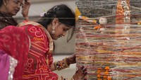 Seorang wanita menempelkan dahinya ke batang pohon beringin yang sudah diktat tapak saat mengikuti ritual menandai festival Vat Purnima di Prayagraj, India, Kamis (6/6/2024).