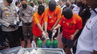 Tiga terangka memasukan sabu cair ke dalam wadah untuk dimusnahkan saat ungkap kasus narkotika di Polda Kepri, Batam, Kepulauan Riau, Kamis (6/6/2024). 