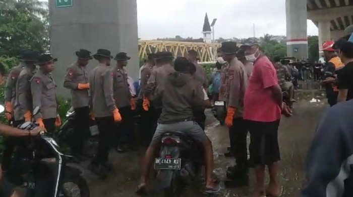 Warga dan polisi saat evakuasi korban di muara sungai kawasan Desa Galala.