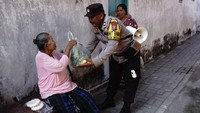 Anggota polisi juga membagikan sayuran gratis kepada warga sembari berpatroli.  