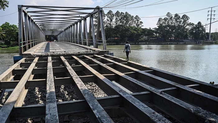 Warga melewati proyek revitalisasi Jembatan Pintu Air 10, Kota Tangerang, Banten, Jumat (7/6/2024). Pemerintah Kota Tangerang merevitalisasi jembatan sepanjang 20 meter dengan anggaran sebesar Rp4,3 miliar yang ditargetkan rampung September 2024. ANTARA FOTO/Sulthony Hasanuddin/YU