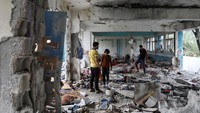Warga mengecek kehancuran yang disebabkan serangan Israel.