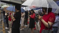 Tak hanya mengantarkan, para orang tua siswa juga menunggu anaknya di luar gedung meski turun hujan.