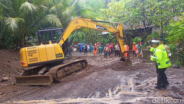 Alat berat dikerahkan untuk membersihkan tanah dan bebatuan yang menutup badan jalan di wilayah Sang Hyang Ambu, Desa Bugbug, Karangasem, Bali, Jumat (7/6/2024). (Foto: I Wayan Selamat Juniasa/detikBali)