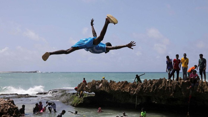A boy jumps into the Indian Ocean waters in Hamarweyne district of Mogadishu, Somalia June 7, 2024. REUTERS/Feisal Omar