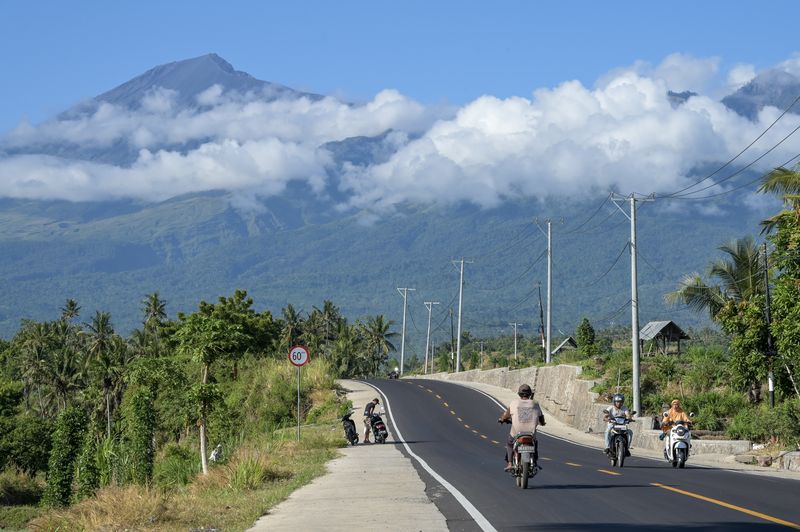 Pengendara sepeda motor melintas di jalan yang baru selesai ditingkatkan menuju kawasan wisata Gunung Rinjani di Senaru, Kecamatan Bayan, Tanjung Lombok Utara, NTB, Sabtu (8/6/2024). Pemerintah setempat meningkatkan kualitas sejumlah ruas jalan dari Tanjung, Lombok Utara menuju kawasan wisata Gunung Rinjani Sembalun agar memudahkan pengunjung mengaksesnya dalam rangka peningkatan angka kunjungan wisata ke Lombok. ANTARA FOTO/Ahmad Subaidi/nz