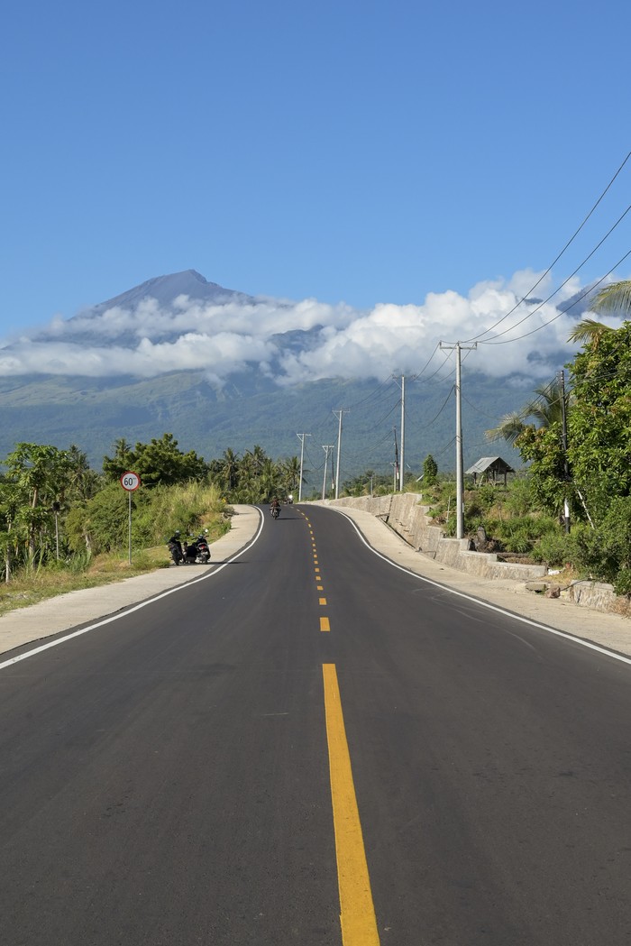 Pengendara sepeda motor melintas di jalan yang baru selesai ditingkatkan menuju kawasan wisata Gunung Rinjani di Senaru, Kecamatan Bayan, Tanjung Lombok Utara, NTB, Sabtu (8/6/2024). Pemerintah setempat meningkatkan kualitas sejumlah ruas jalan dari Tanjung, Lombok Utara menuju kawasan wisata Gunung Rinjani Sembalun agar memudahkan pengunjung mengaksesnya dalam rangka peningkatan angka kunjungan wisata ke Lombok. ANTARA FOTO/Ahmad Subaidi/nz