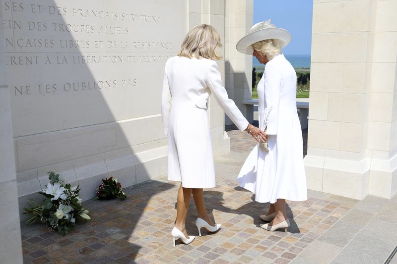 Raja Charles III dan Ratu Camilla Bertemu Presiden Prancis Emmanuel Macron dan Ibu Negara Prancis Brigitte Macron Britain's Queen Camilla and Brigitte Macron lay flowers during the UK Ministry of Defence and the Royal British Legion's commemorative event at the British Normandy Memorial to mark the 80th anniversary of D-Day, in Ver-Sur-Mer, France, Thursday, June 6, 2024. (Chris Jackson, Pool Photo via AP)