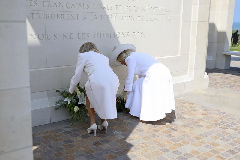 Raja Charles III dan Ratu Camilla Bertemu Presiden Prancis Emmanuel Macron dan Ibu Negara Prancis Brigitte Macron Britain's Queen Camilla and Brigitte Macron lay flowers during the UK Ministry of Defence and the Royal British Legion's commemorative event at the British Normandy Memorial to mark the 80th anniversary of D-Day, in Ver-Sur-Mer, France, Thursday, June 6, 2024. (Chris Jackson, Pool Photo via AP)
