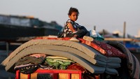 Seorang warga Palestina duduk di atas barang-barangnya saat ia melarikan diri dari Rafah akibat operasi militer Israel, 7 Juni 2024.