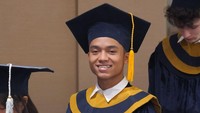 Senyum semringan Betrand Peto mengikuti momen wisuda. Dia terlihat memakai toga berwarna biru dongker dengan corak garis berwarna kuning. Foto: dok. Instagram Betrand Peto