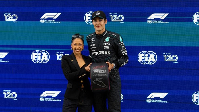 MONTREAL, CANADA - JUNE 8: George Russell of Great Britain and Mercedes signs the pole position trophy held by YouTuber Liza Koshy after qualifying ahead of the F1 Grand Prix of Canada at Circuit Gilles Villeneuve on June 8, 2024 in Montreal, Canada. (Photo by Kym Illman/Getty Images)