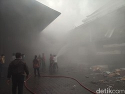 Petugas dari Dinas Pemadam Kebakaran (Damkar) Denpasar berjibaku memadamkan api yang membakar gudang LPG dan pipa paralon di tengah kepungan asap. Air diseprotkan ke areal gudang yang terbakar. (Ahmad Firizqi Irwan/detikBali)