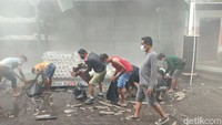 Para karyawan yang bekerja di lokasi kebakaran memungut pipa-pipa tercecer yang masih bisa diselematkan. (Ahmad Firizqi Irwan/detikBali)