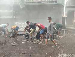 Para karyawan yang bekerja di lokasi kebakaran memungut pipa-pipa tercecer yang masih bisa diselematkan. (Ahmad Firizqi Irwan/detikBali)