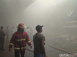 Asap pekat mengepul di sekitar area gudang akibat kebakaran yang terbakar. Terlihat petugas pemadan kabakaran bertugas di lokasi. Masyarakat yang berada di sana beberapa di antaranya tampak menggunakan masker guna melindungi hidung dan mulut dari paparan asap. (Ahmad Firizqi Irwan/detikBali)