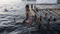 Anak-anak sedang mandi di laut kawasan Cilincing, Jakarta, Sabtu (8/6/2024).