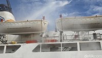 Foto: Upaya pemadaman di KM Umsini di Pelabuhan Soekarno Hatta Makassar dilakukan dengan menggunakan kapal pandu dan mobil pemadam kebakaran (damkar). (Urwatul Wutsqaa/detikSulsel)