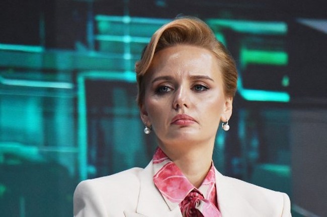 Rambut pirangnya disanggul dengan gaya aristokrat klasik, di mana poni depan dibuat bergelombang dan bagian belakang dibuat bervolume. Maria tampak memakai riasan wajah tipis dengan pulasan lipstik rose-pink. Foto: Maria Vorontsova (AFP/OLGA MALTSEVA)