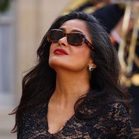 Kesan glamor tetap terakomodasi lewat rok A-line yang megar. Padanan clutch kulit senada makin memaksimalkan penampilannya. (Foto: Marc Piasecki/Getty Images)