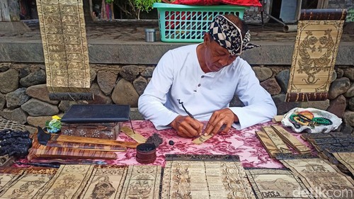 Seni melukis daun lontar atau prasi di Desa Tenganan Pegringsingan, Karangasem, makin diminati turis asing.