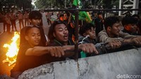 Massa aksi sempat memanjat beton pembatas di jalan Medan Merdeka Barat.