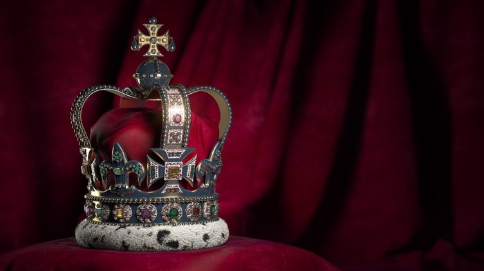 Royal golden crown with jewels on pillow on pink red background. Symbols of UK United Kingdom monarchy. 3d illustration