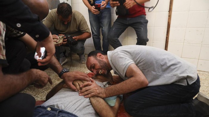 Korban Tewas Gaza Terus Meningkat, Kini Tembus 37 Ribu Orang A Palestinian mourns his relative killed in the Israeli bombardment of the Gaza Strip at al-Aqsa Hospital in Deir al Balah on Sunday, June 9, 2024. (AP Photo/Saher Alghorra)