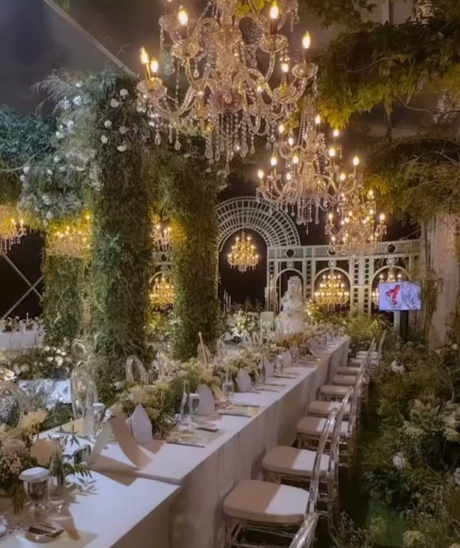 Meja para tamu juga tak kalah cantik dengan taplak putih dan bangku berwarna senada. Bagian tengah meja dihiasi dengan bunga-bunga berwarna putih. Sementara di atas meja-meja tersebut terdapat chandelier-chandelier yang berjejer. Foto: Instagram