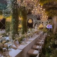 Meja para tamu juga tak kalah cantik dengan taplak putih dan bangku berwarna senada. Bagian tengah meja dihiasi dengan bunga-bunga berwarna putih. Sementara di atas meja-meja tersebut terdapat chandelier-chandelier yang berjejer. Foto: Instagram